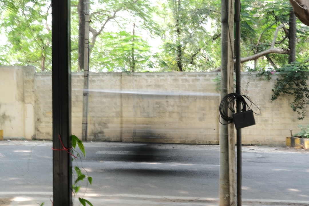 Motion blur of a motorcycle moving along the tree-shaded street