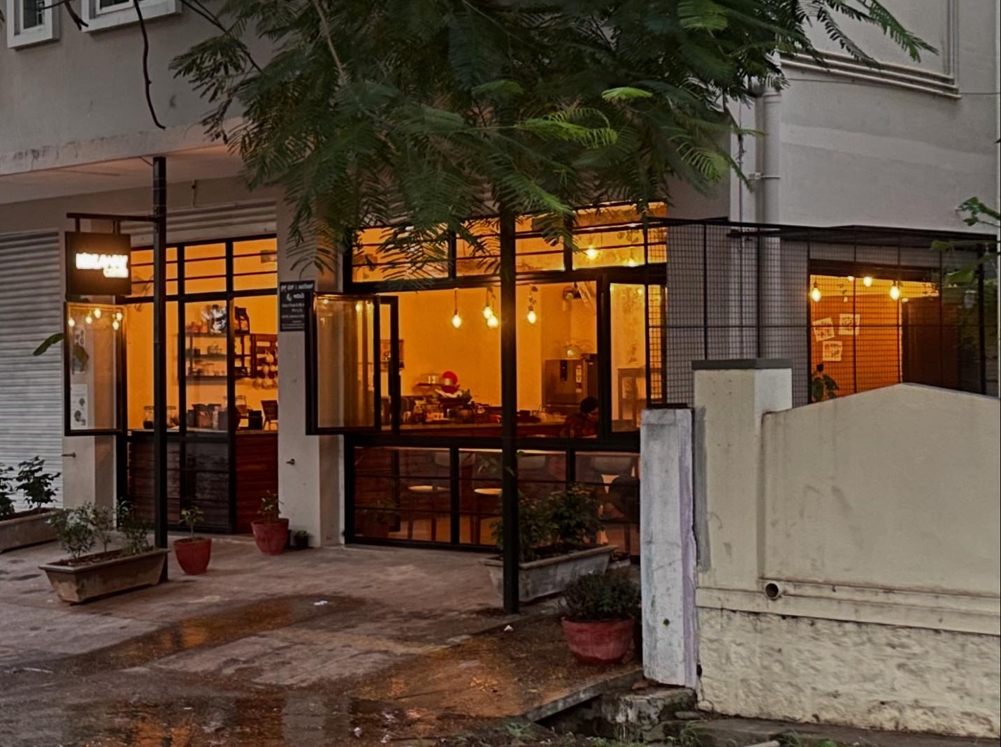 Evening view of Hideaway Coffee cafe with warm lighting visible through large windows