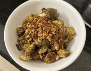 Roasted Brussels Sprouts with Zesty Lemon and Garlic Dressing in a white ceramic bowl.